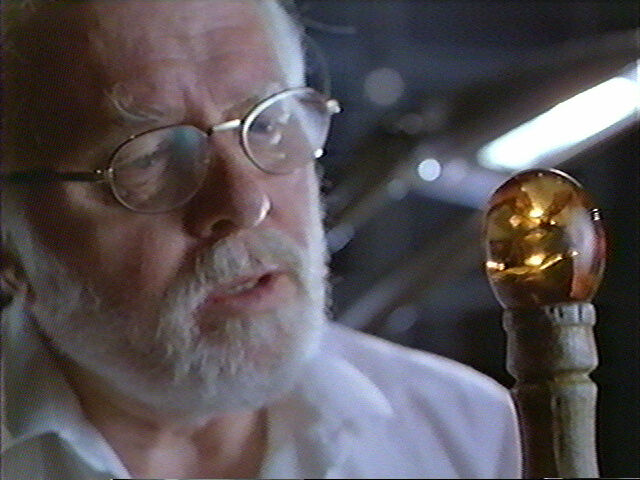 John Hammond looks at the mosquito entrapped in his amber tipped walking stick.